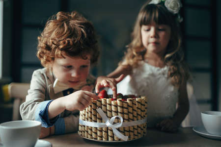 happy boy and girl having tea party in cafeの写真素材