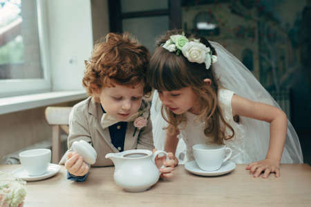 happy boy and girl having tea party in cafeの写真素材