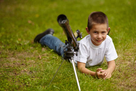 photo of happy little boy with telescopeの写真素材