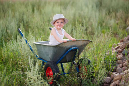 photo of cute little boy with wheelbarrowの写真素材