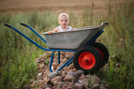 photo of cute little boy with wheelbarrowの写真素材