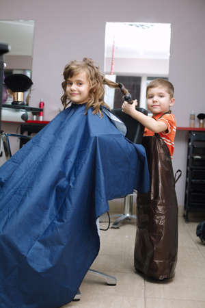two funny children play in the barbershopの写真素材