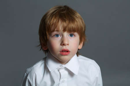 little serious boy portrait on dark background