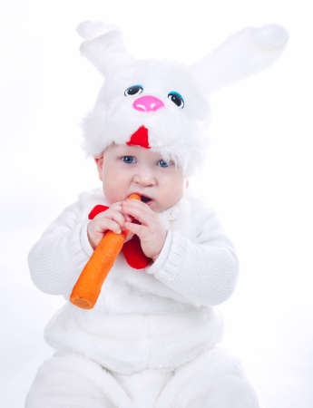 little beautiful boy in rabbit costume with carrot isolatedの写真素材