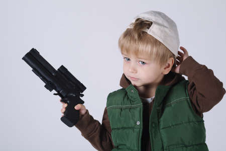 photo of little boy with gun on whiteの写真素材