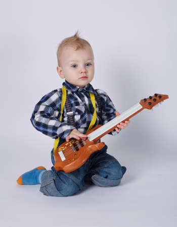 photo of little funny boy with guitar