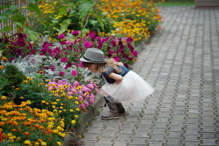photo of little beautiful girl in flowers parkの写真素材