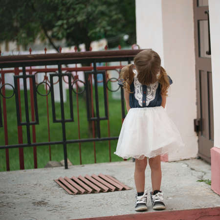 photo of little cute shy girl on the streetの写真素材