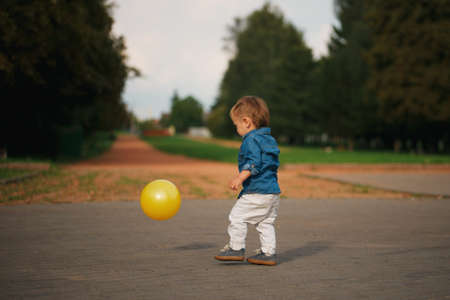 Photo of happy little boy playing with yellow ballの写真素材