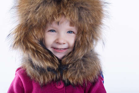 little funny girl with fur hat on white backgroundの写真素材