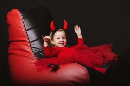 photo of funny little devil on dark backgroundの写真素材
