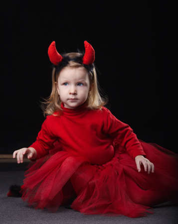 photo of funny little devil on dark background