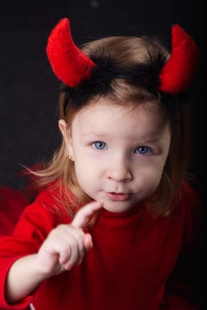 photo of funny little devil on dark background
