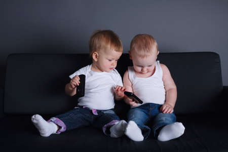 photo of two children with mobile phonesの写真素材