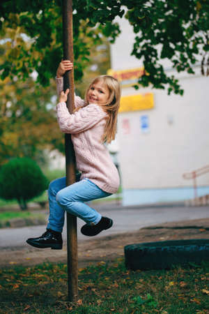 photo of young happy girl climbing the poleの写真素材