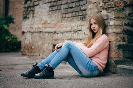 photo of beautiful young girl posing on the streetの写真素材