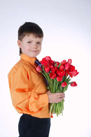 photo of beautiful boy with big bouquet of tulipsの写真素材