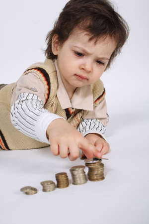 cute little boy plays with coinsの写真素材