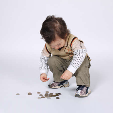 cute little boy plays with coins