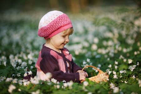 beautiful little girl in forest on flowers fieldの写真素材