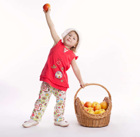 cute little girl with apple and basketの写真素材