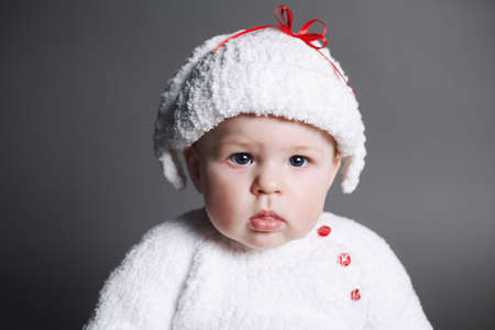 beautiful baby in a knit dress and cap