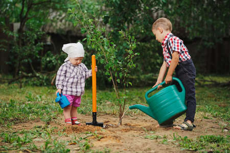 Little funny boy with shovel in gardenの写真素材
