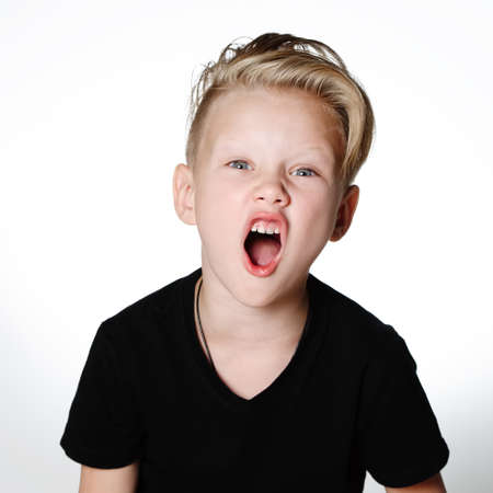 Young emotional boy on bright backgroundの写真素材