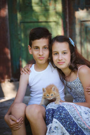 young girl and boy with red kittenの写真素材