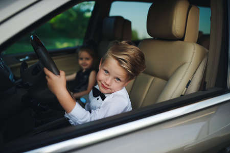 little boy driving car with girlfriendの写真素材