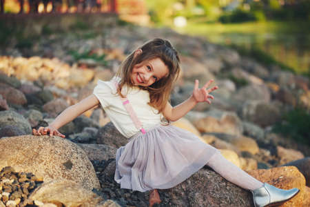 little girl playing on stones beachの写真素材