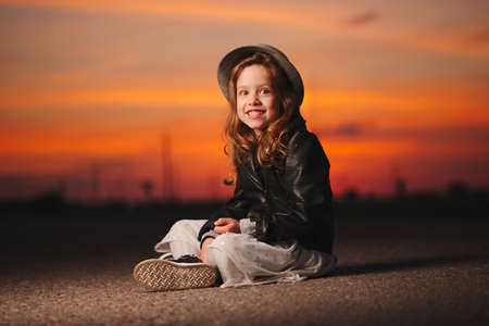 little girl with hat on evening sunsetの写真素材
