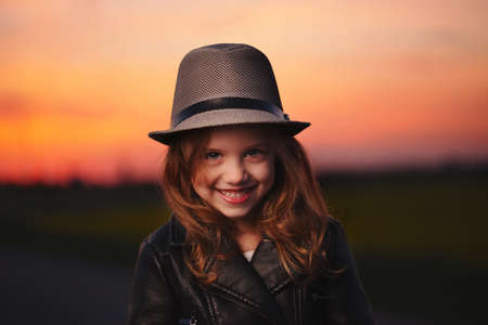 little girl with hat on evening sunsetの写真素材