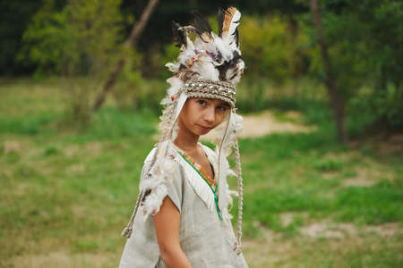 little funny boy playing native american