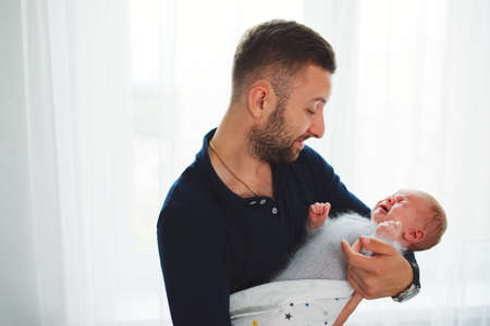 Father with cute crying newborn babyの写真素材