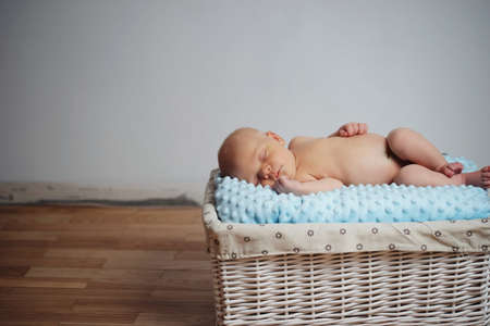 Cute newborn baby lying on the basketの写真素材