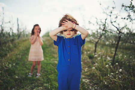 Little boy and girl in blooming gardenの写真素材