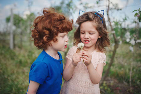 Little boy and girl in blooming gardenの写真素材