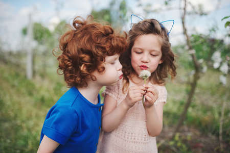 Little boy and girl in blooming gardenの写真素材