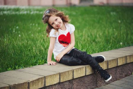 cute smiling girl sitting outdoorsの写真素材