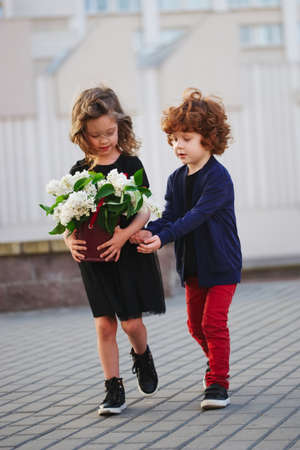 Little boy and girl with big lilac bouquetの写真素材