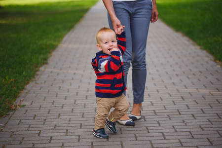 mother holding son by handの写真素材
