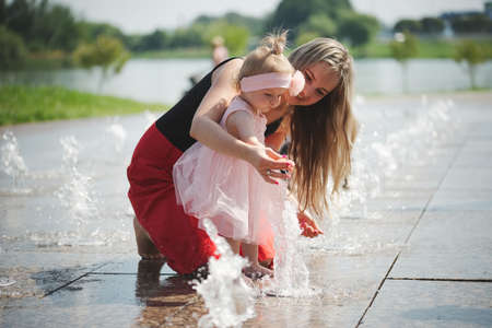 young mother with daughter at fountainの写真素材