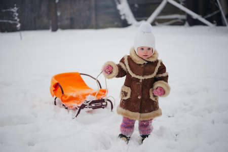 cute girl with sled in snowの写真素材