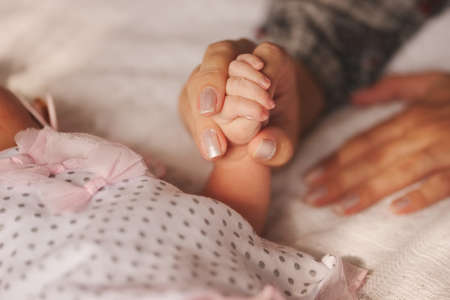 mother holds little hand of newborn babyの写真素材