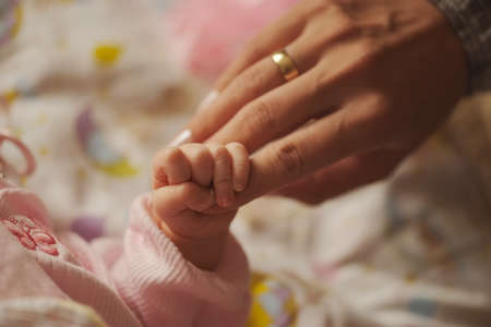 mother holds little hand of newborn babyの写真素材