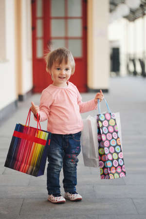 cute little girl with shopping bagsの写真素材