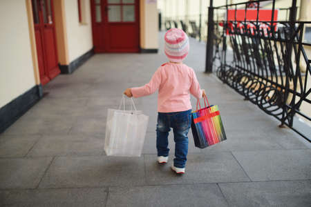 cute little girl with shopping bagsの写真素材