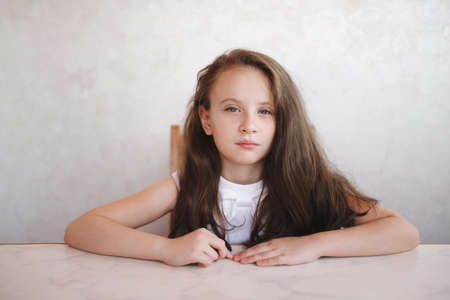 little girl sitting at the tableの写真素材