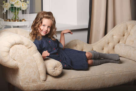 little funny girl posing on sofaの写真素材